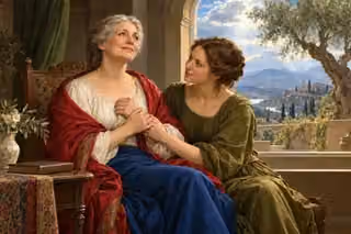 An older woman rests in prayer while her daughter holds her hand beside an olive tree window.