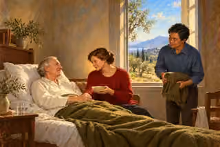 A woman offers soup and holds an older man's hand at his bedside while an East Asian friend brings a folded blanket in a warmly lit home.